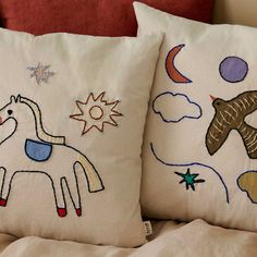 two pillows with embroidered animals on them