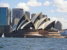 the sydney opera house is in front of some tall buildings on the water's edge