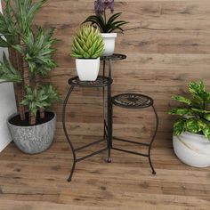 three potted plants are sitting next to each other on a stand in front of a wooden wall