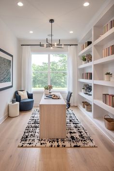 a living room filled with furniture next to a window covered in white curtains and bookshelves