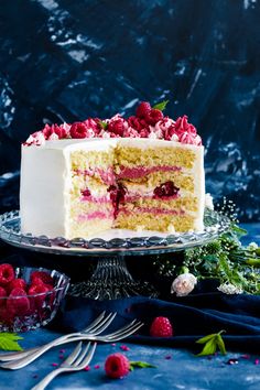 a cake with white frosting and raspberries on top