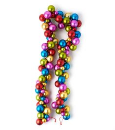 the letter j is made up of multicolored balls and tassels on a white background