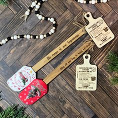 three wooden tags with words on them are hanging from a string next to some pine branches