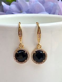 Lightweight and easy to wear, these dainty earrings are also elegant and classic. The bezel set 8mm faceted round onyx gemstones are surrounded by sparkly cz's set in gold bezels and suspended from equally sparkly gold ear wires that have cz's set in them as well. All jewelry is sent to you packaged in a gift box that is tied off with ribbon and a charm, ready for gift giving. Luxury Onyx Earrings For Formal Occasions, Elegant Black Round Cut Earrings, Gold Faceted Earrings For Evening, Gold Earrings With Halo Setting, Elegant Gold Earrings With Halo Setting, Elegant Gold Faceted Crystal Earrings, Elegant Gold Earrings With Bezel Setting, Gold Earrings With Gemstone Accents In Cubic Zirconia, Gold Earrings With Gemstone Accents And Cubic Zirconia