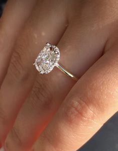 a woman's hand with a diamond ring on top of her finger and an engagement band