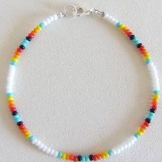 a multicolored beaded bracelet is displayed on a white surface with a silver clasp