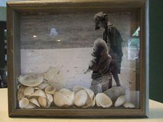 there is a glass frame with shells in it