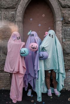 three people dressed up as ghostes standing in front of a door with bubbles all over them