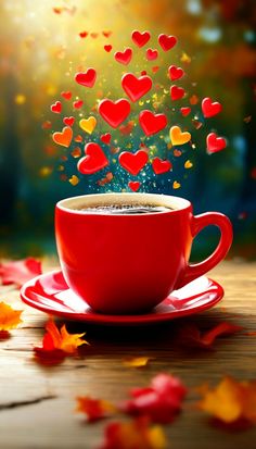 a cup of coffee with hearts coming out of it on a saucer surrounded by autumn leaves