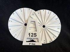 two white clocks with the numbers twenty and nine on each side, one has an upside down clock