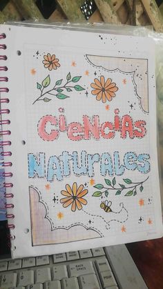 a notebook with the words cienja naturales written on it next to a keyboard