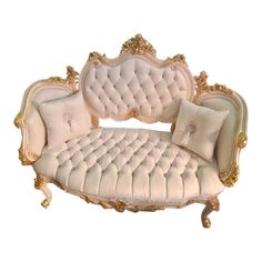 a white couch with gold trimmings and pillows on it's back end