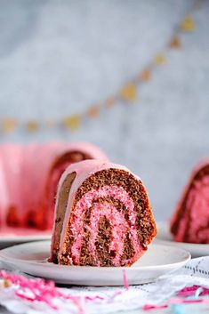 a piece of cake on a plate with pink icing and sprinkles