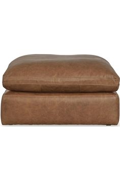 a large brown leather ottoman sitting on top of a white floor