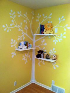 a child's room with yellow walls and white tree painted on the wall