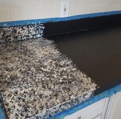 the counter top is covered in black and white marbles with blue tape on it