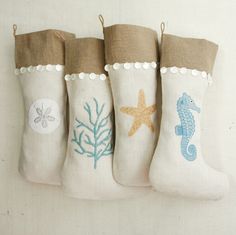 three christmas stockings with seahorses and starfish on them hanging from the wall