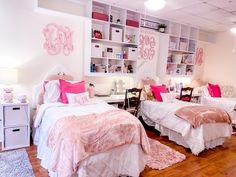 two beds in a room with pink and white decor