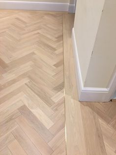 an empty room with wood flooring and white trim on the walls, next to a door