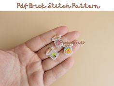 small cross stitch earrings in the palm of someone's hand with text overlay that reads, puff brick stitch patterns