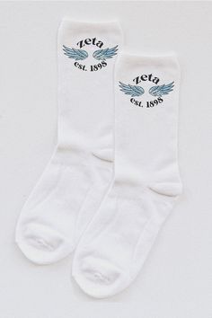 two pairs of white socks with blue wings on the bottom and one pair has black lettering