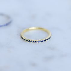 Sweet, simple, and dainty eternity band. Perfect for a minimalist look, or for stacking. ☆ Details ☆ * Made of 925 Sterling Silver * Available in 14k Gold Plating or Rhodium * We use a THICK, DURABLE plating - for a piece that will last you years to come! * VERY HIGH QUALITY * Available in sizes 4, 5, 6, 7, 8, 9, or 10 * Features stones throughout the entire ring * Measures 1.3mm in thickness * Made of Highest Grade Blue CZ stones for an authentic Sapphire Look * Also available in White CZ, Ruby Stackable Adjustable Eternity Band For Everyday, Adjustable Minimalist Stackable Eternity Band, Minimalist Adjustable Stackable Eternity Band, Minimalist Half Eternity Band For Everyday, Everyday Minimalist Stackable Eternity Band, Dainty Stackable Eternity Band Ring, Everyday Stackable Half Eternity Rings, Dainty Everyday Stackable Rings With Prong Setting, Minimalist Everyday Half Eternity Jewelry