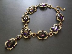 Featuring clear/pink rhinestones crystals and purple glass stones and linked to cable chain.Just elegant and romantic!!Color: antiqued brass with clear/pink rhinestones crystals and purple glass stones   Size: necklace measures around 21” long x 1.15” width x 2.5 center drop ** Please note we need to take around 5 days to make it.  Please be patient. **Item ship out with tracking number to you (around 10 to 14 business days for delivery).We also provide fast shipping service, around 3-4 business Glamorous Purple Jewelry For Evening, Purple Jewelry With Sparkling Stones For Party, Purple Jeweled Wedding Necklace, Elegant Purple Bridal Necklace For Wedding, Formal Purple Jewelry With Sparkling Stones, Purple Jeweled Necklace For Party, Elegant Purple Necklace For Party, Glamorous Jeweled Crystal Necklace For Gift, Glamorous Jeweled Crystal Necklaces For Gifts