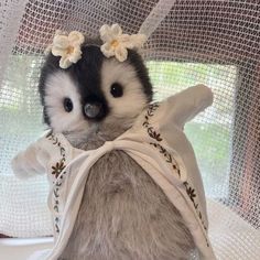 a stuffed animal with flowers in it's hair sitting on top of a table