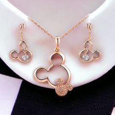 This Beautiful Rose Gold Plated Jewelry Set Features A Charming Mickey Mouse Design That Is Perfect For Any Disney Lover. The Set Includes A Necklace And Earrings, Making It A Great Gift For Occasions Such As Mother's Day, Birthdays, Graduations Or Anniversaries. Crafted With High-Quality Crystal And Zinc, This Set Is Durable And Elegant. The Round, White/Colorless Main Stone Adds A Touch Of Classic Luxury, While The Rose Gold Metal Finish Provides A Modern And Stylish Look. Vintage Christmas Earrings, Mouse Necklace, Mickey Mouse Necklace, Alex And Ani Bangles, Mickey Mouse Design, Earrings Making, Artisan Necklace, Gold Cross Pendant, Disney Lover