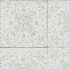 a white tile wall with an intricate design