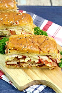 two sandwiches cut in half sitting on top of a cutting board