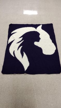 a rug with a horse head on it in the middle of a flooring area