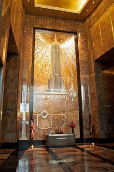 the entrance to empire building in new york city, with an american flag hanging from the ceiling