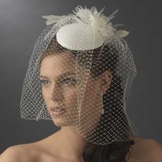 a woman wearing a veil with flowers on the side and a birdcage over her head