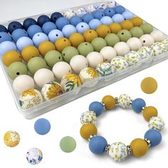 an assortment of beads and bracelets in a plastic container on a white surface next to it