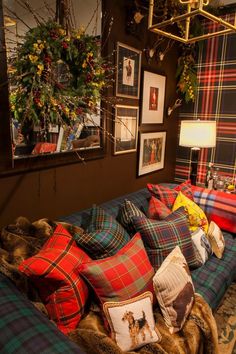 a living room filled with lots of pillows and blankets on top of a blue couch