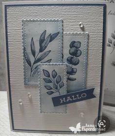 a close up of a card with some leaves on it and a blue ribbon around the edges