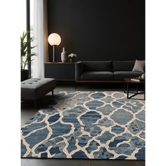 a blue and white rug in a living room next to a couch with a lamp on it