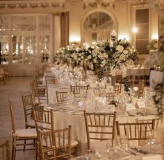 the tables are set up with white flowers and place settings for dinner guests to enjoy