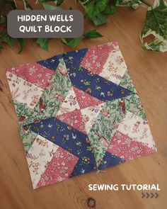 the hidden wells quilt block pattern is shown on a wooden table with green plants in the background