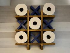 several rolls of toilet paper are arranged on a wooden rack with blue tape around them