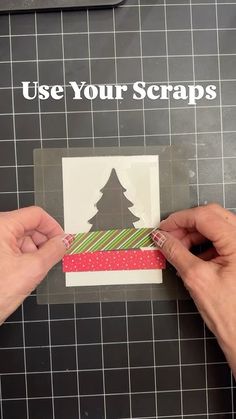 someone is cutting out a christmas card with scissors and tape to make it look like a tree