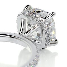 an engagement ring with a princess cut diamond in the center and side stones on each band