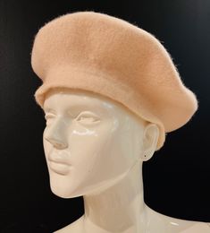 a white mannequin head with a beige hat on it's head and black background