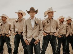 a group of men standing next to each other wearing cowboy hats