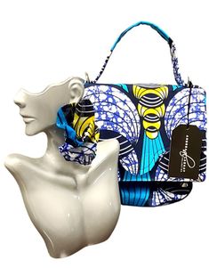 Introducing our latest addition to the Andrea Lashay Collection - a stunning handcrafted purse paired with matching earrings. This set features a vibrant blue, yellow, and black abstract print that exudes artistic flair and bold fashion. The purse, measuring 9 x 6 inches, is designed with a sturdy blue handle, making it a stylish statement piece for any fashion-forward individual. Matching Earrings: The accompanying earrings are designed to perfectly complement the purse, showcasing the same vibrant colors and patterns. These dangle-style earrings add a touch of elegance and complete the look effortlessly. Note from the Designer: As I embark on my journey into purse making, I want to share that while these purses are not yet perfected, they are crafted with love and a keen eye for style. E Trendy Blue Shoulder Bag For Gift, Trendy Blue Handmade Shoulder Bag, Chic Handmade Blue Shoulder Bag, Artistic Handmade Blue Bags, Chic Blue Shoulder Bag Gift, Chic Blue Shoulder Bag For Gift, Artistic Blue Bag As Gift, Artistic Blue Bag As A Gift, Artistic Blue Bags As Gift