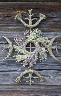 an intricately designed piece of art made out of branches and flowers on a wooden wall