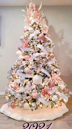 a white christmas tree with pink and silver ornaments