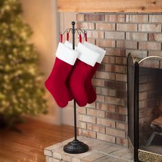 two stockings hanging on a stand next to a fireplace