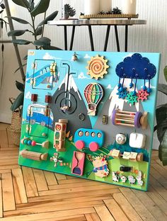 a wooden board with various items on it sitting on the floor next to a potted plant